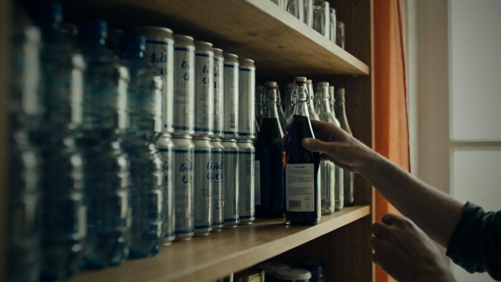 Neatly stacked water canisters and bottles on a storage shelf show how drinking water is stored for emergencies