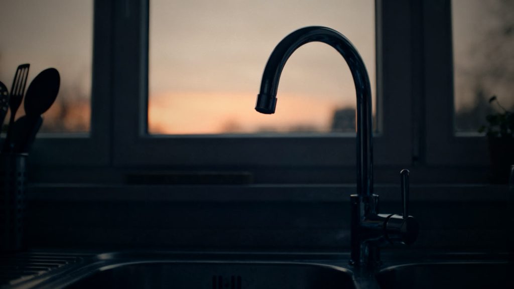 Wasserhahn in einer Küche bei Dämmerlicht, Wasser bei Stromausfall nicht immer verfügbar